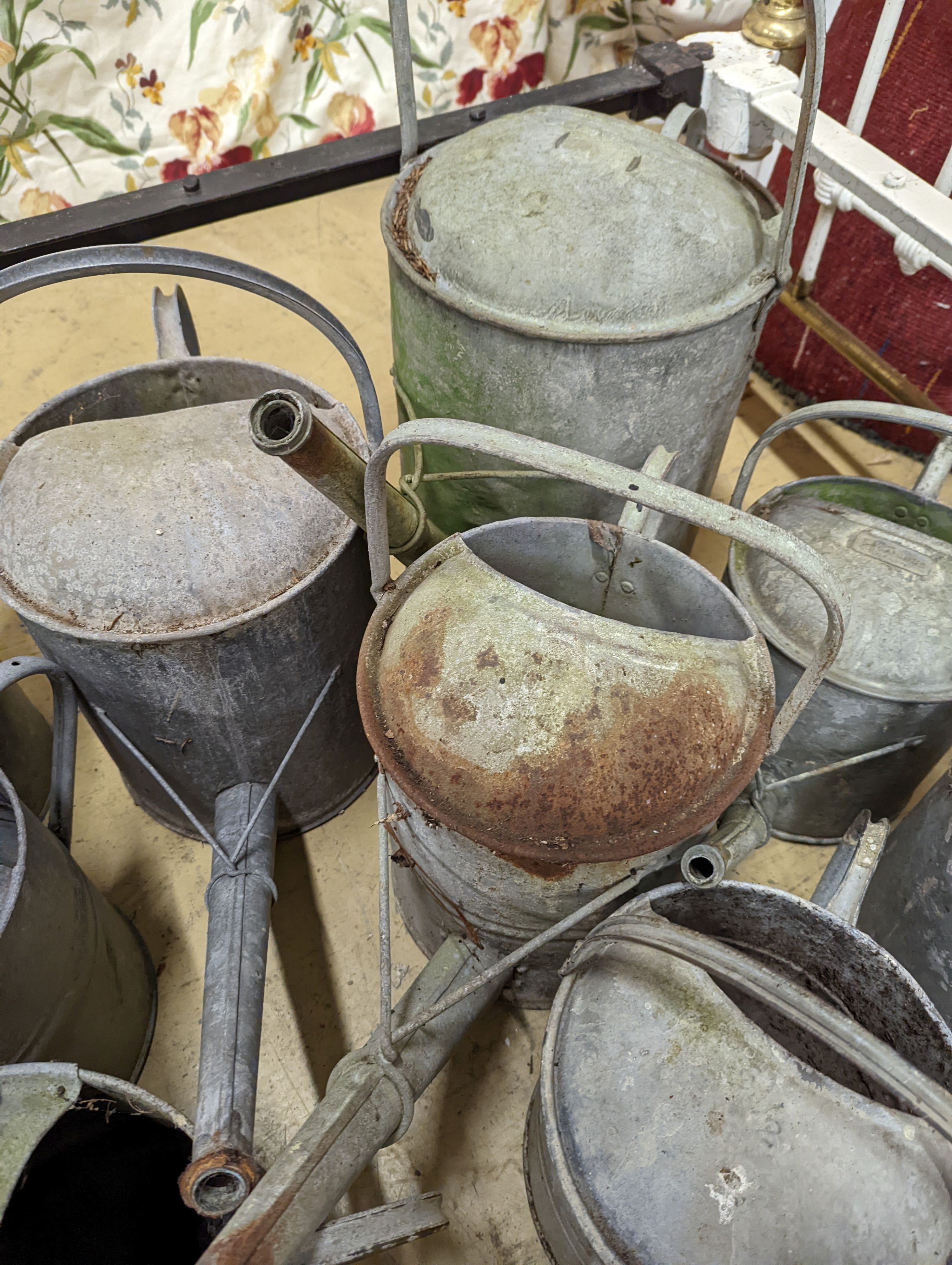 Ten vintage galvanised watering cans.